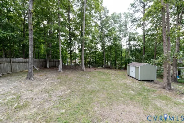 a view of backyard with a barn and large trees