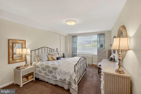 a bedroom with a bed and a dresser with mirror