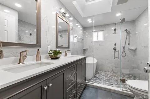 a bathroom with a double vanity sink toilet and shower