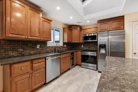 a kitchen with stainless steel appliances granite countertop a stove a sink and a refrigerator