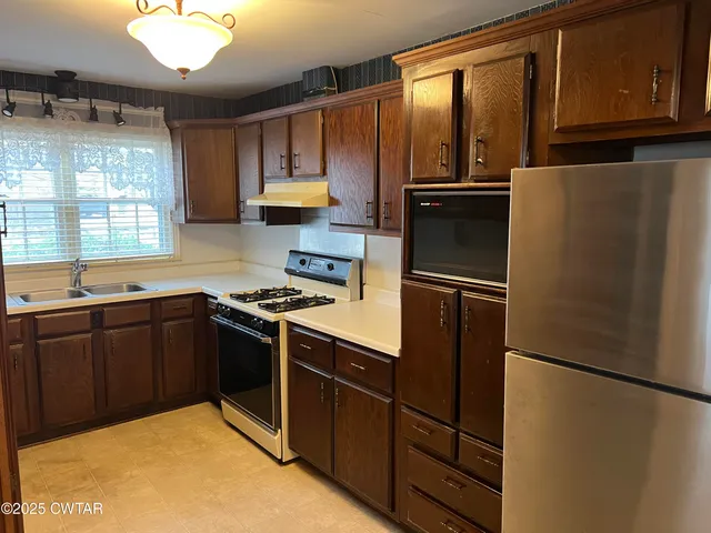 a kitchen with granite countertop a refrigerator and a sink