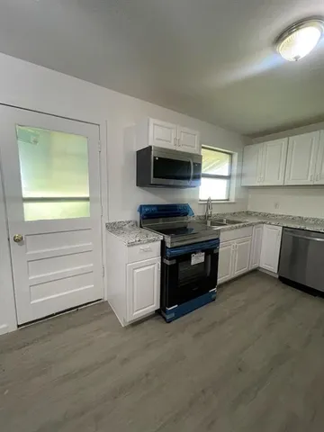 a kitchen with granite countertop stainless steel appliances and cabinets