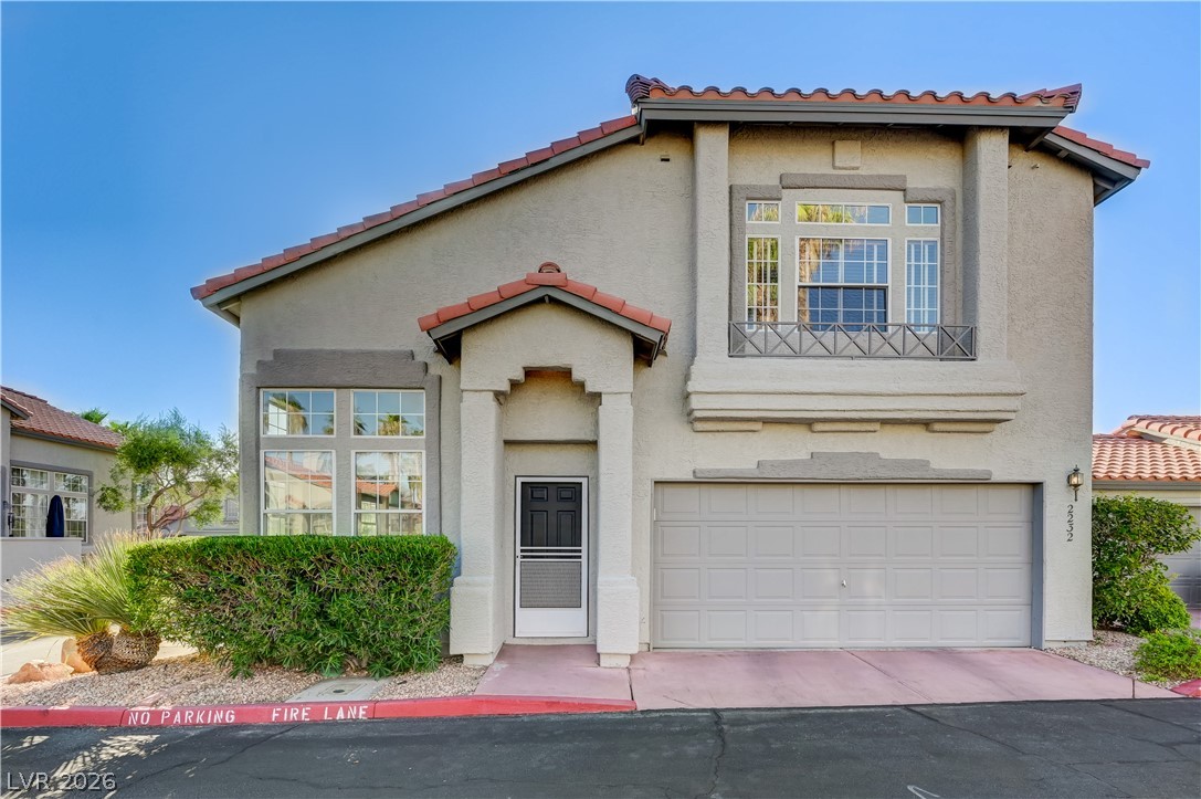 Spanish tile accents and a structured entryway define this modern multi-level residence facade.