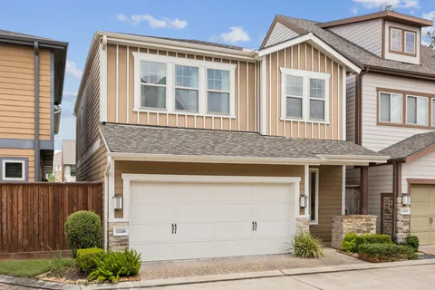 a large kitchen with kitchen island a large window a sink stainless steel appliances and cabinets