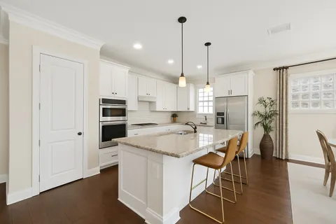 a kitchen with granite countertop white cabinets and sink