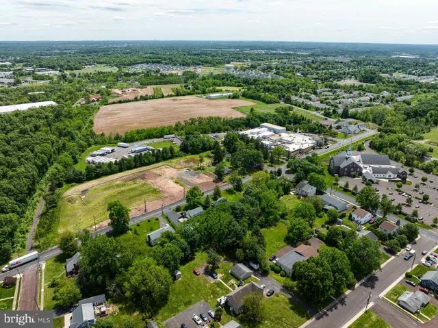 an aerial view of residential houses with outdoor space and trees