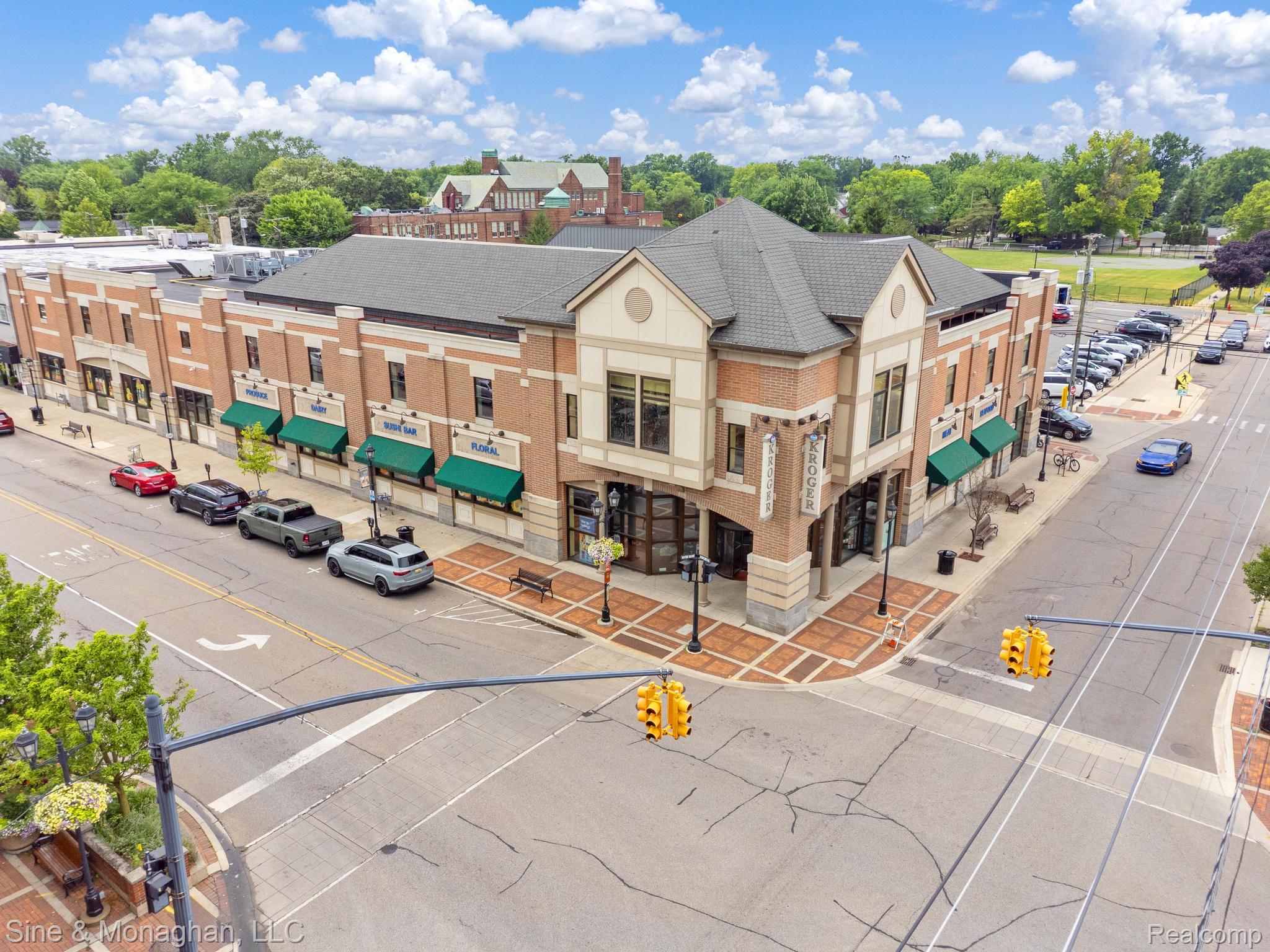 679 Neff Road Grosse Pointe, MI 48230 - Photo 62 of 78 Brick and stucco mixed-use building featuring multiple storefronts, green awnings, and a prominent corner presence