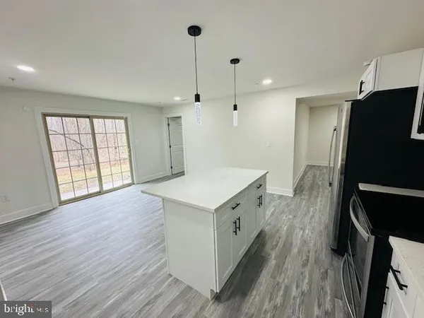 a kitchen with a refrigerator a sink and wooden floor