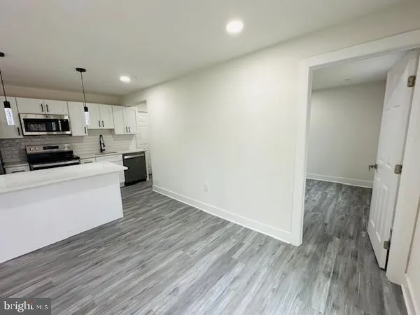 a view of kitchen with wooden floor and electronic appliances