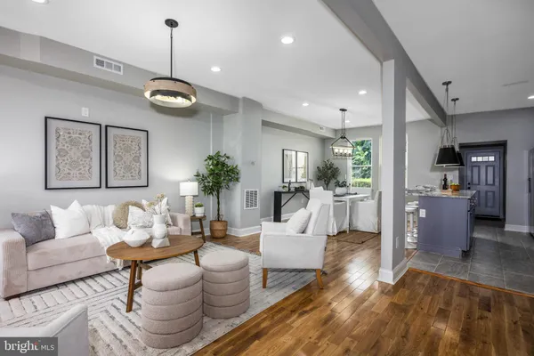 a living room with furniture kitchen view and a chandelier