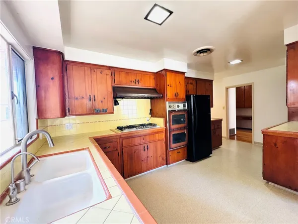 a large kitchen with stainless steel appliances granite countertop a refrigerator and a sink