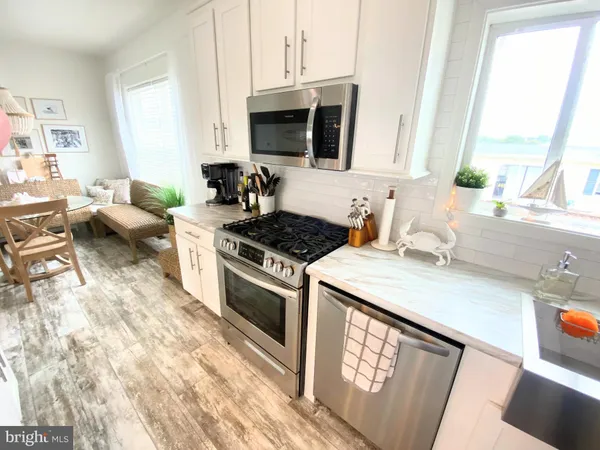 a kitchen with stainless steel appliances a stove a sink a stove and a microwave