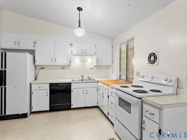 a kitchen with granite countertop a stove sink and refrigerator