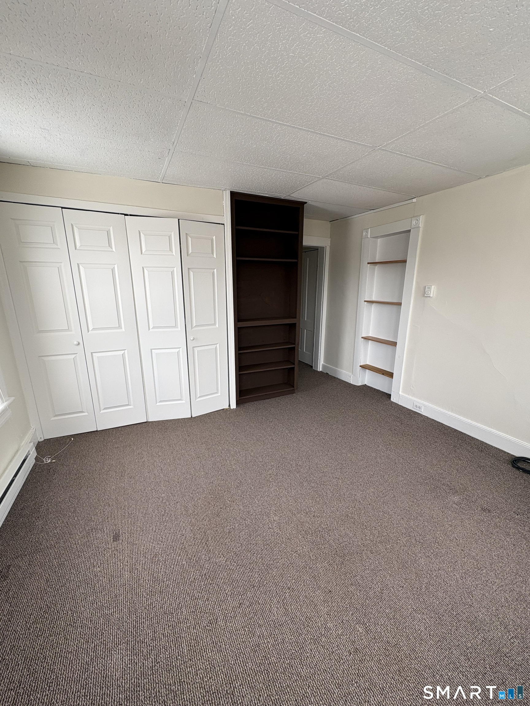 a view of empty room with closet and cabinet