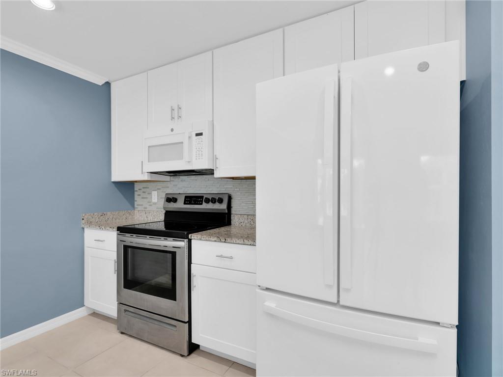 731 Hadley Place West Naples, FL 34104 - Photo 16 of 30 Kitchen With White Shaker Cabinets, Island, Granite Countertops, Added Backsplash, Pantry, New White GE Dishwasher, Microwave, And Refrigerator With Icemaker, And Stainless Steel Frigidaire Range With Self-Cleaning Oven.