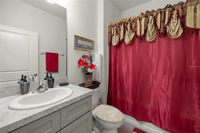 a bathroom with a toilet a sink and a mirror