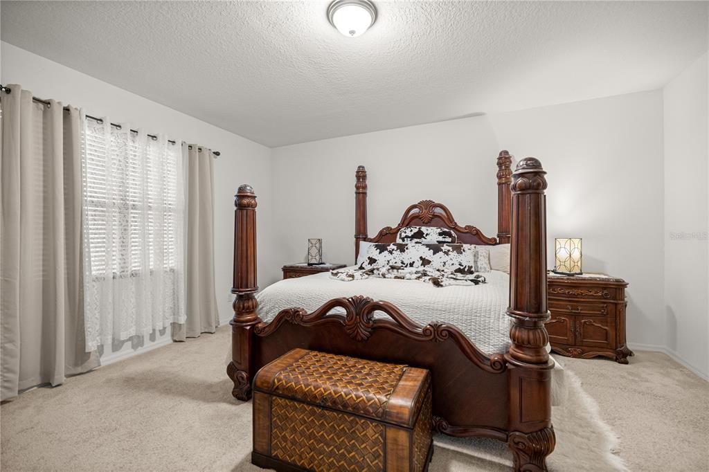 6474 Southwest 89th Loop Ocala, FL 34476 - Photo 10 of 34 a bedroom with a bed and a chandelier