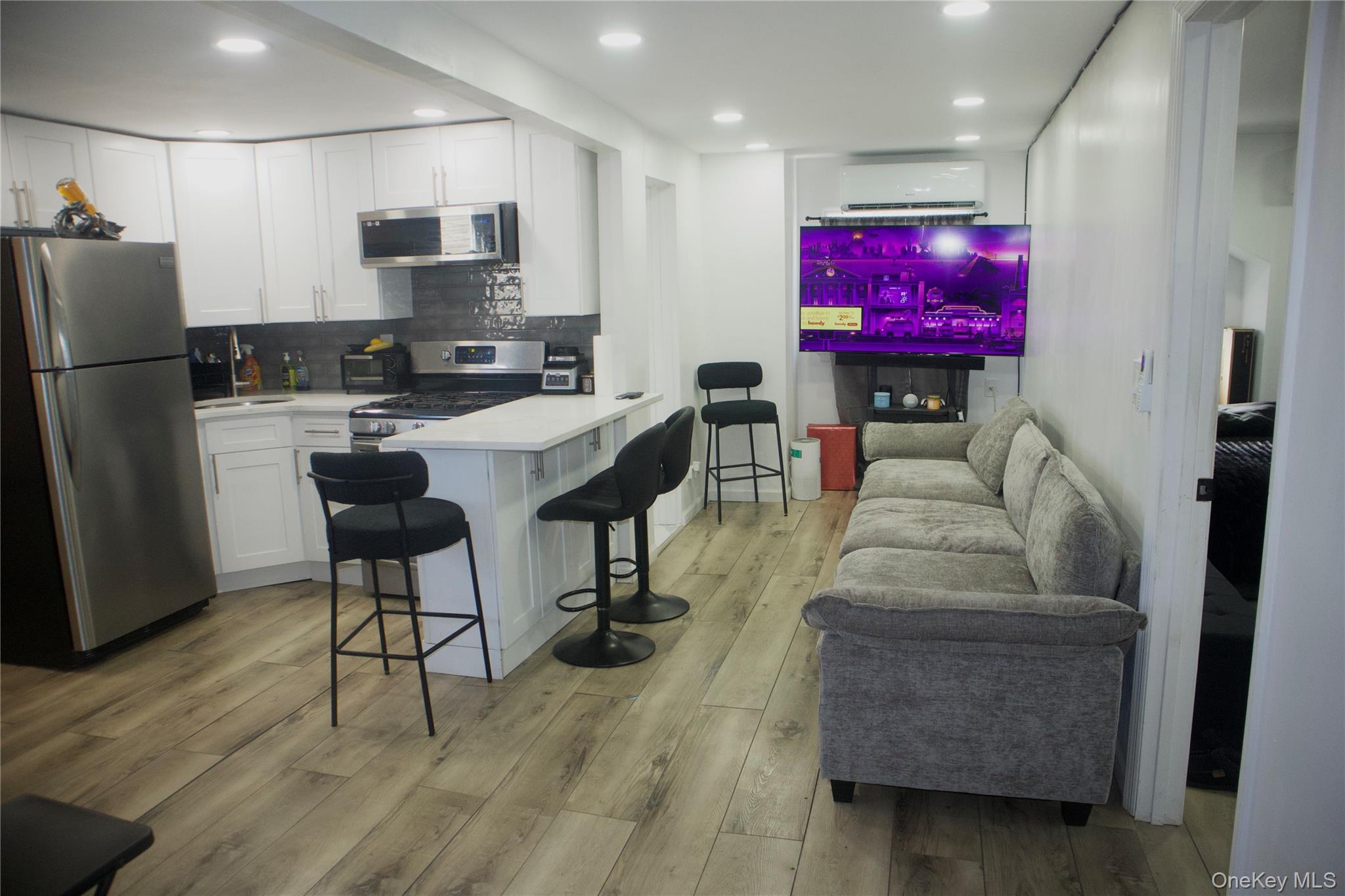 147-15 223rd Street Queens, NY 11413 - Photo 18 of 21 a living room with furniture a kitchen view and a refrigerator