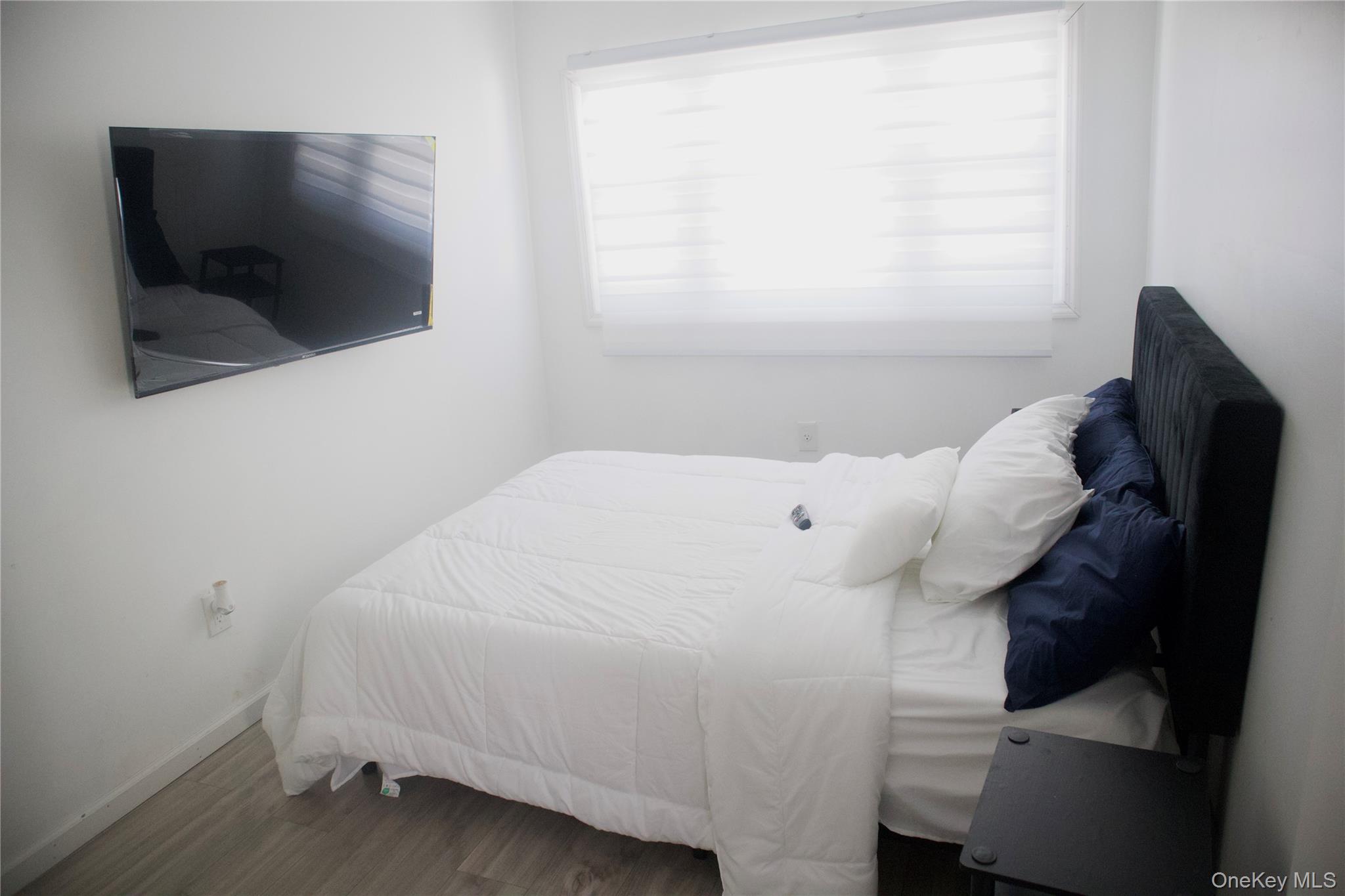 147-15 223rd Street Queens, NY 11413 - Photo 5 of 21 a bedroom with a bed and a flat screen tv