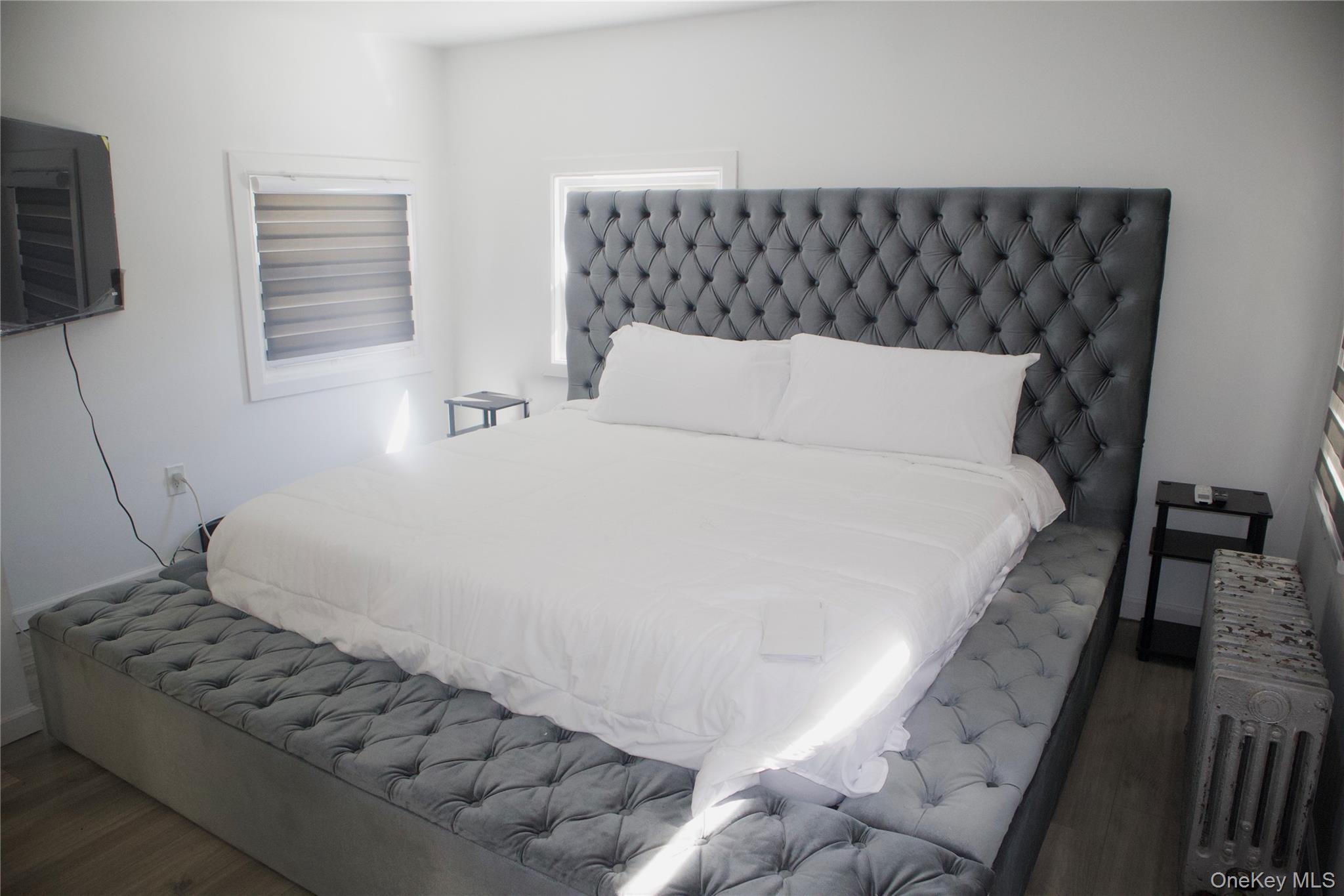 147-15 223rd Street Queens, NY 11413 - Photo 9 of 21 a large white bed in a small room