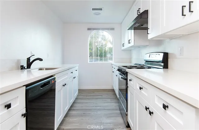 a kitchen with cabinets appliances a sink and a window