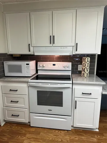 a stove top oven sitting inside of a kitchen
