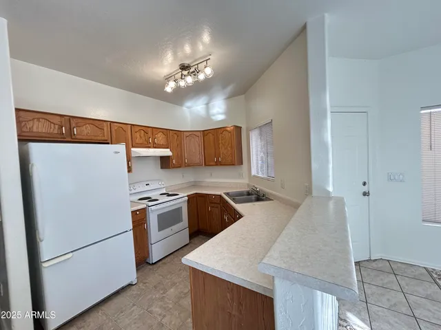 a kitchen with stainless steel appliances granite countertop hardwood floor sink stove and refrigerator