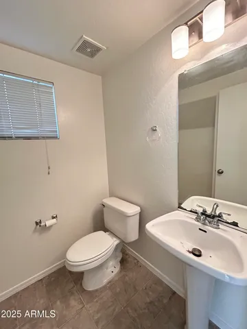 a bathroom with a sink a toilet and mirror