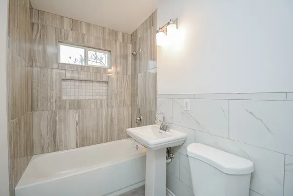 a bathroom with a sink a toilet and shower