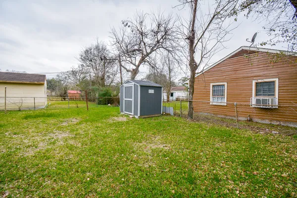 a view of a house with backyard and a tree
