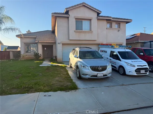 a front view of a house with a garden and parking space