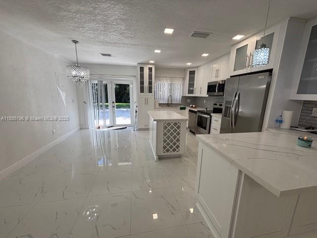 a kitchen with stainless steel appliances a refrigerator sink and microwave