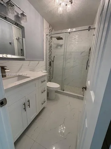 a bathroom with a double vanity sink toilet and shower