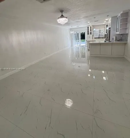 a kitchen with white cabinets and window