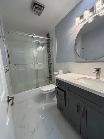 a bathroom with a double vanity sink toilet mirror and shower