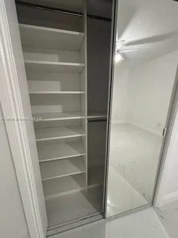 a view of walk in closet with empty racks