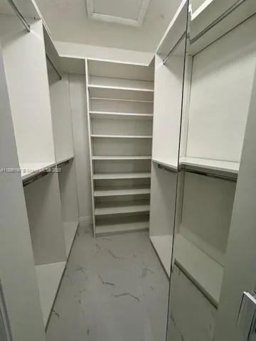 a view of walk in closet with empty racks