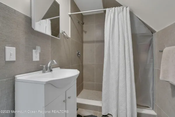 a bathroom with a sink mirror and shower