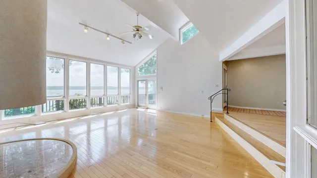 a large white kitchen with granite countertop a sink and dishwasher with a large window