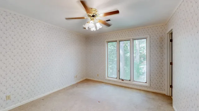 a view of a house with a yard and large tree