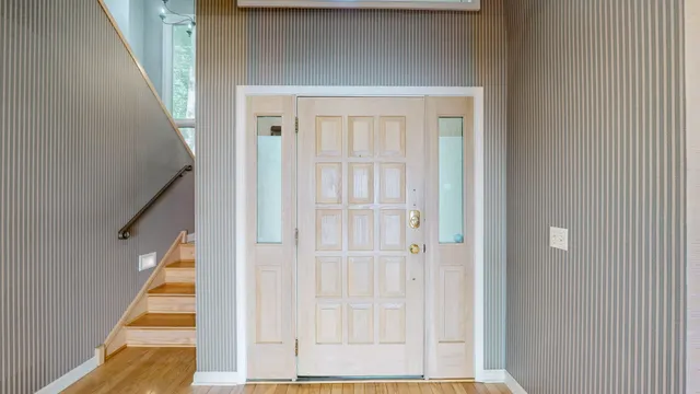 a view of a hallway with wooden floor and chandelier