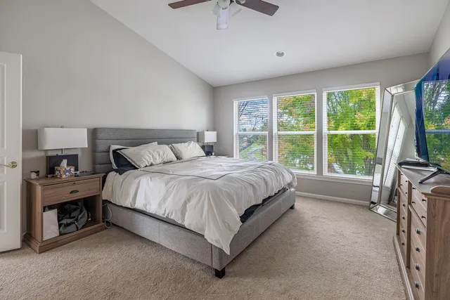 a spacious bedroom with a bed and a large window