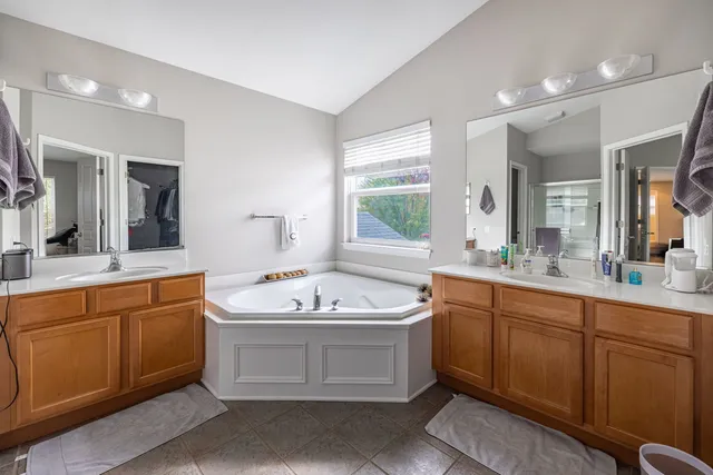 a spacious bathroom with a sink double vanity mirror and bathtub
