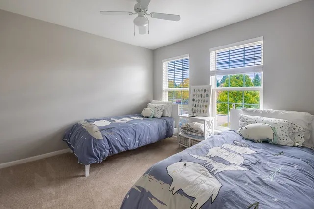 a bedroom with bed and a large window