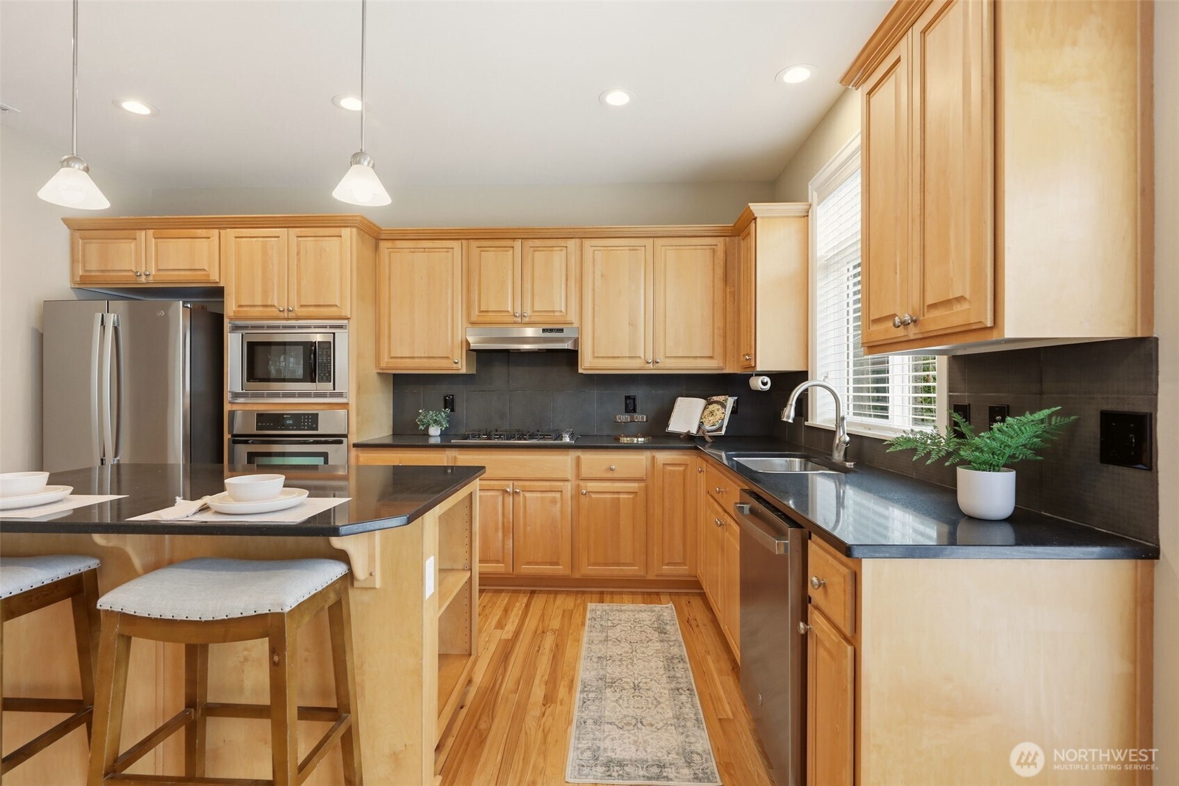 3501 156th Place Southeast Bothell, WA 98012 - Photo 15 of 36 a kitchen with stainless steel appliances granite countertop a sink refrigerator and cabinets