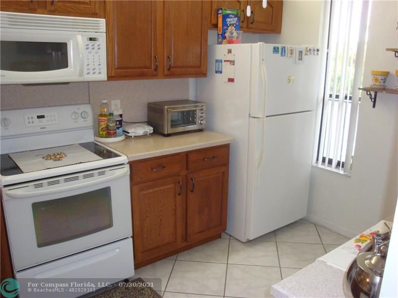 Coral Gate Margate, FL 33063 - Photo 5 of 28 a kitchen with a refrigerator sink stove and cabinets