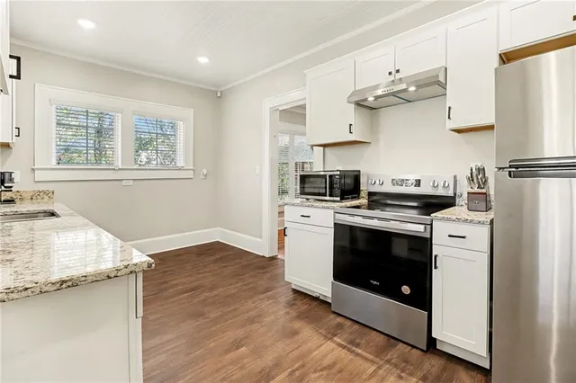 a kitchen with stainless steel appliances granite countertop a stove a refrigerator and a sink