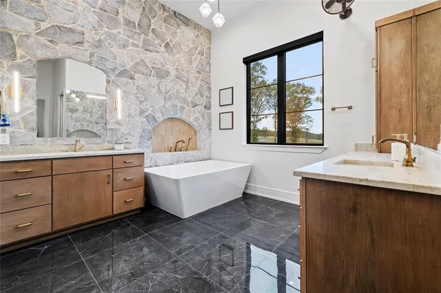 a bathroom with a double vanity sink a mirror and a bathtub
