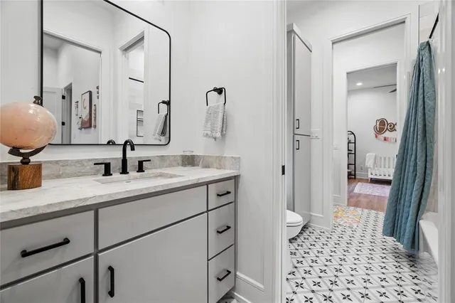 a bathroom with a sink a toilet and a mirror