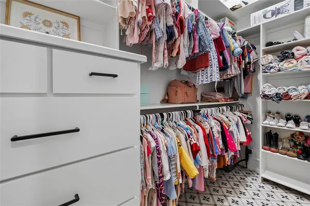a view of walk in closet with clothes and shoes